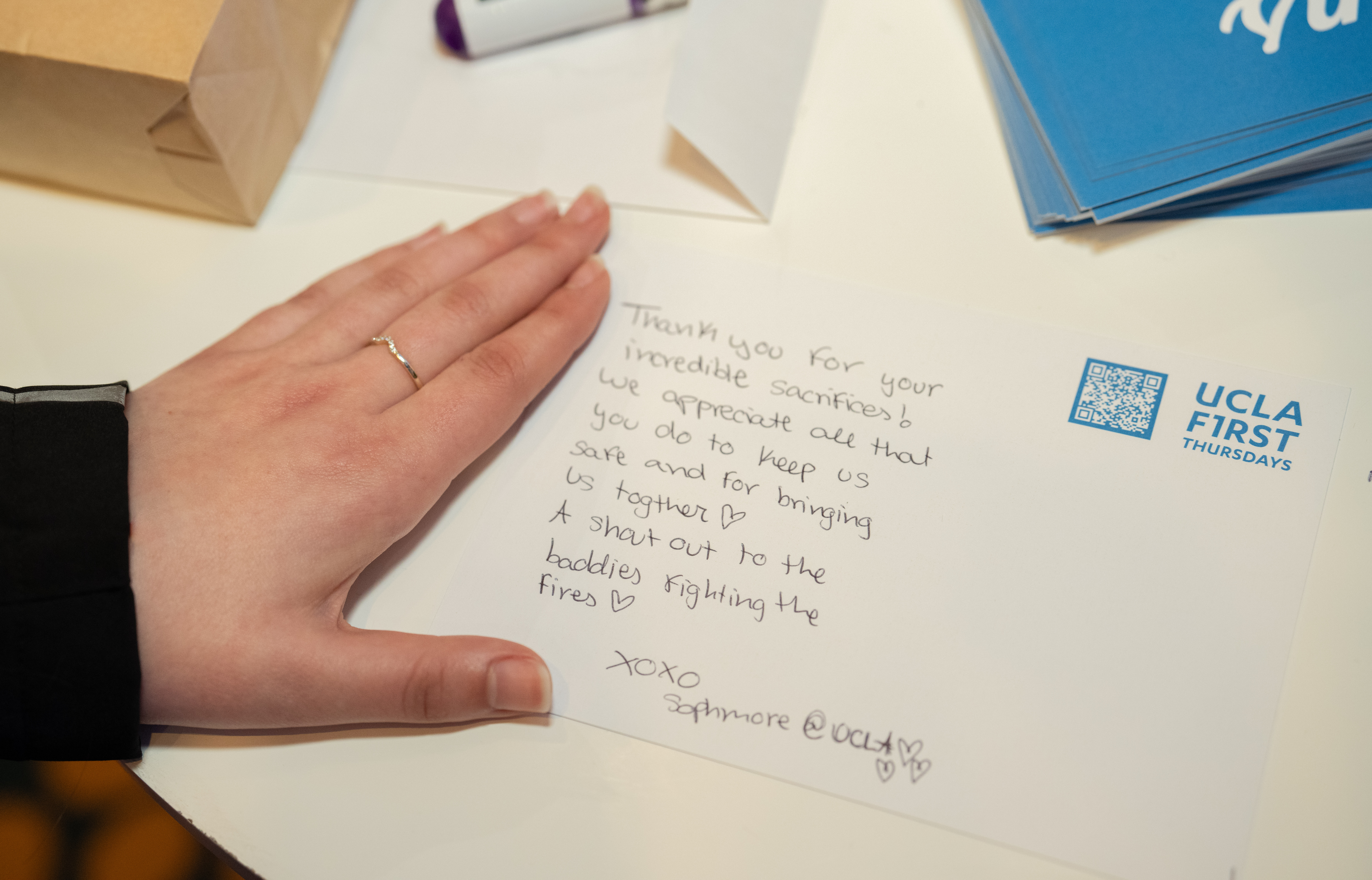 Close-up of hand on top of thank-you letter to first responders