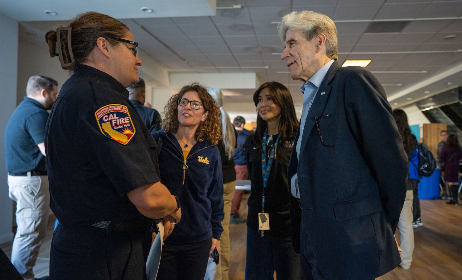 UCLA Chancellor Julio Frenk speaks with a representative of the California Department of Forestry and Fire Prevention at the opening of the disaster recovery center